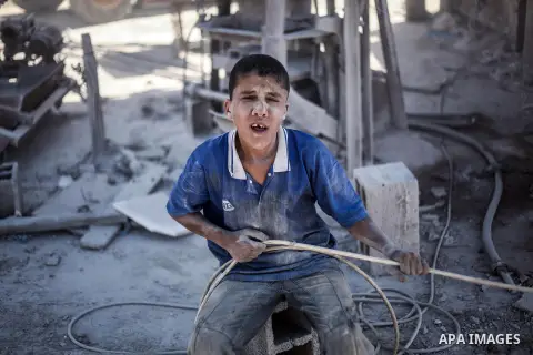 A Palestinian laborer works on a crusher machine at a brick factory in center Gaza Strip, Aug 22, 2013. Palestinians re-use old bricks in construction after the Egyptian army started to knock down Gaza smuggling tunnels...