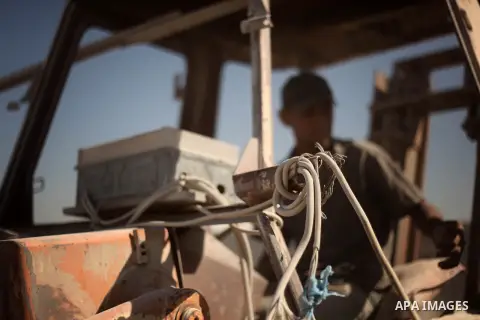 A Palestinian laborer works on a crusher machine at a brick factory in center Gaza Strip, Aug 22, 2013. Palestinians re-use old bricks in construction after the Egyptian army started to knock down Gaza smuggling tunnels...