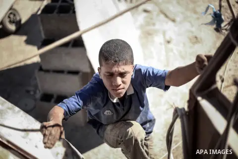 A Palestinian laborer works on a crusher machine at a brick factory in center Gaza Strip, Aug 22, 2013. Palestinians re-use old bricks in construction after the Egyptian army started to knock down Gaza smuggling tunnels...
