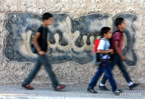 Palestinian students return back to their school in the morning of the first day of the new year study in the West Bank city of Nablus, on Aug. 25, 2013. Photo by Nedal Eshtayah