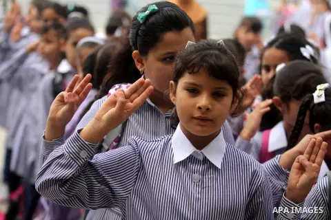 Palestinian students return back to their school in the morning of the first day of the new year study in the West Bank city of Ramallah, on Aug. 25, 2013. Photo by Issam Rimawi