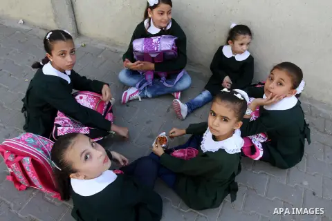 Palestinian students return back to their school in the morning of the first day of the new year study in Gaza city, on Aug. 25, 2013. Photo by Mohammed Asad
