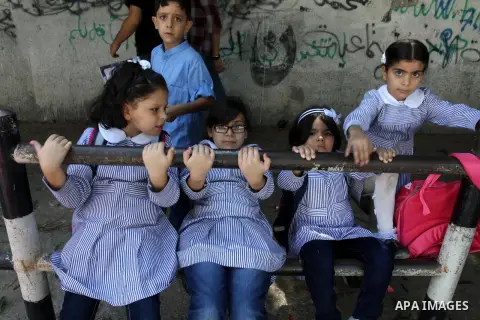 Palestinian students return back to their school in the morning of the first day of the new year study in Gaza city, on Aug. 25, 2013. Photo by Mohammed Asad