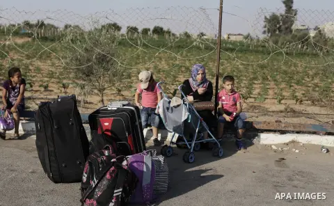 Palestinians wait to cross into Egypt at the Rafah crossing between Egypt and the southern Gaza Strip August 25, 2013. Egypt reopened its border crossing with the Gaza Strip on Saturday after four days of closure, allowi...