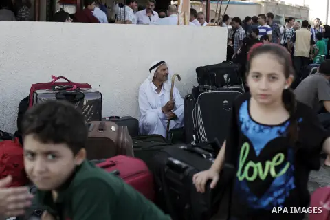 Palestinians wait to cross into Egypt at the Rafah crossing between Egypt and the southern Gaza Strip August 25, 2013. Egypt reopened its border crossing with the Gaza Strip on Saturday after four days of closure, allowi...