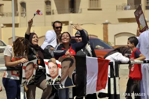 Supporters of former Egyptian president Hosni Mubarak wave his portrait outside the Police Academy ahead of his trial on August, 25 2013 in Cairo. An Egyptian court adjourned the murder and corruption retrial of former s...
