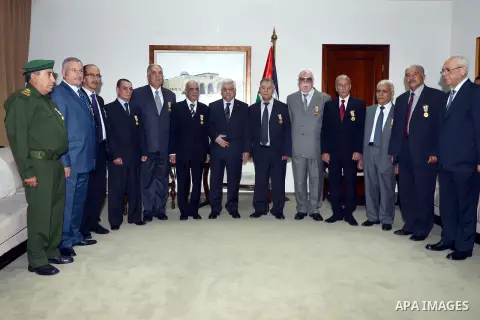 Palestinian President Mahmoud Abbas poses for a photograph with the former security chiefs following honoring ceremony in the West Bank City of Ramallah, Aug 25, 2013. Photo by Thaer Ganaim
