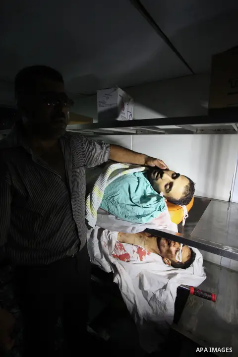 A man shows the body of a Palestinian man who was killed during clashes with Israeli security forces in Qalandia refugee camp, at a hospital in the West Bank city of Ramallah on August 26, 2013. An Israeli police spokesw...