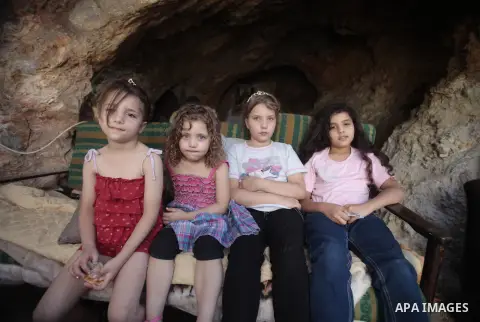 Daughters of Khaled al-Zeer al-Husaini, 39, sit at their father's cave in the east Jerusalem Arab neighbourhood of Silwan, August 26, 2013. Al-Husaini is a father of five children live in a cave, which was a stable for a...