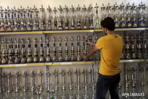 A Palestinian man displays hookahs 'also known as waterpipes', at his shop in Gaza City on Aug 27, 2013. Photo by Ashraf Amra