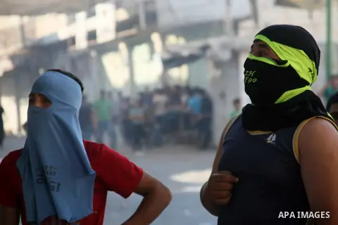 Palestinians throw stones towards Israeli soldiers (unseen) during clashes following a protest against Israeli settlements on August 27,2013 in the city center of the West Bank town of Hebron. Israeli-Palestinian peace t...