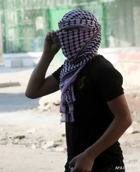 A Palestinian protester throws stones towards Israeli soldiers (unseen) during clashes following a protest against Israeli settlements on August 27,2013 in the city center of the West Bank town of Hebron. Israeli-Palesti...