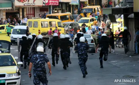 Palestinian security forces step in to prevent Palestinian protesters from throwing stones during clashes following a protest against Israeli settlements on August 27,2013 in the city center of the West Bank town of Hebr...