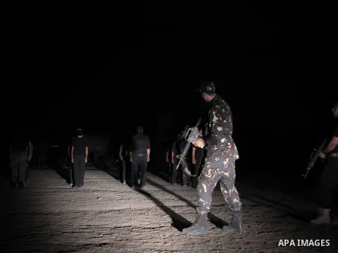 Palestinian militants of al-Nasser Salah al-Din Brigades, the armed wing of the Popular Resistance Committees (PRC), take part in a night military-style exercises at a training camp in Rafah in the southern Gaza Strip, A...