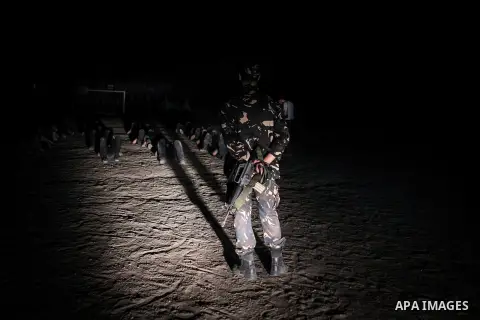 Palestinian militants of al-Nasser Salah al-Din Brigades, the armed wing of the Popular Resistance Committees (PRC), take part in a night military-style exercises at a training camp in Rafah in the southern Gaza Strip, A...