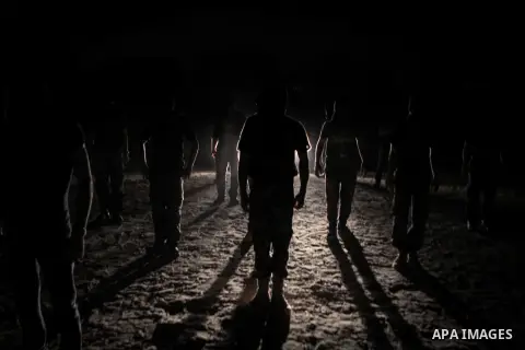 Palestinian militants of al-Nasser Salah al-Din Brigades, the armed wing of the Popular Resistance Committees (PRC), take part in a night military-style exercises at a training camp in Rafah in the southern Gaza Strip, A...