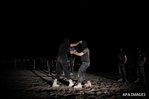 Palestinian militants of al-Nasser Salah al-Din Brigades, the armed wing of the Popular Resistance Committees (PRC), take part in a night military-style exercises at a training camp in Rafah in the southern Gaza Strip, A...