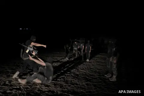 Palestinian militants of al-Nasser Salah al-Din Brigades, the armed wing of the Popular Resistance Committees (PRC), take part in a night military-style exercises at a training camp in Rafah in the southern Gaza Strip, A...