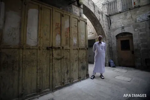 A Palestinian man stands in front of a closed shop during a strike to protest the killing of three Palestinians at Qalandiya Refugee Camp by Israeli troops, in Jerusalem's Old City, 28 August 2013. Israeli troops shot de...