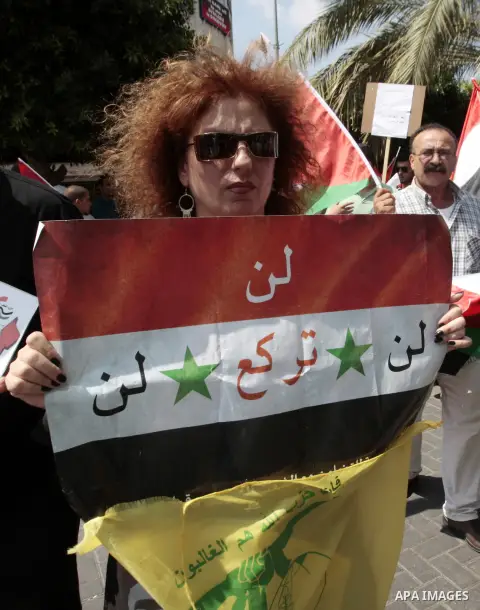 A Palestinian woman holds a Syrian flag during a demonstration against the United States' involvement in Syria, in the West Bank City of Nablus,Aug. 29, 2013. U.S. President Barack Obama on Wednesday declared unequivocal...