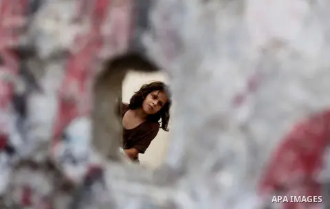 A Palestinian girl plays next to her family's home at al-Shati refugee camp, in Gaza City on Aug 29, 2013. Photo by Ashraf Amra