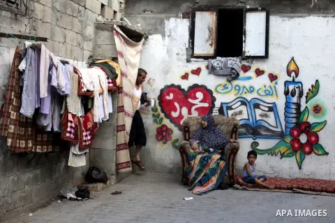 A Palestinian woman sits in front of her home at al-Shati refugee camp, in Gaza City on Aug 29, 2013. Photo by Ashraf Amra
