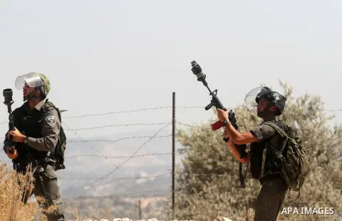 An Israeli border policeman fires tear gas towards Palestinian protesters during clashes after a protest against Israel's separation barrier and in solidarity with Palestinian prisoners being held in Israeli jails, in th...