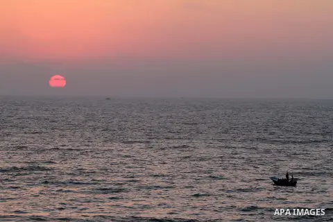 Palestinians ride a boat in the sea during the sunset at Gaza beach during the weekend western Gaza City on Aug 30, 2013. Photo by Mohammed Asad