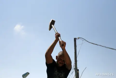 A Palestinian laborer works on a crusher machine at a brick factory in Rafah in southern Gaza Strip, Aug 31, 2013. Palestinians re-use old bricks in construction after the Egyptian army started to knock down Gaza smuggli...