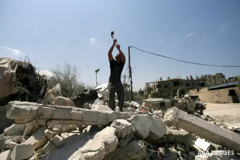 A Palestinian laborer works on a crusher machine at a brick factory in Rafah in southern Gaza Strip, Aug 31, 2013. Palestinians re-use old bricks in construction after the Egyptian army started to knock down Gaza smuggli...