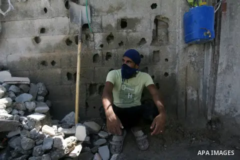 A Palestinian laborer works on a crusher machine at a brick factory in Rafah in southern Gaza Strip, Aug 31, 2013. Palestinians re-use old bricks in construction after the Egyptian army started to knock down Gaza smuggli...