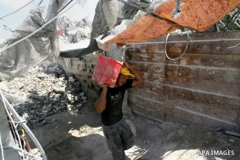 A Palestinian laborer works on a crusher machine at a brick factory in Rafah in southern Gaza Strip, Aug 31, 2013. Palestinians re-use old bricks in construction after the Egyptian army started to knock down Gaza smuggli...