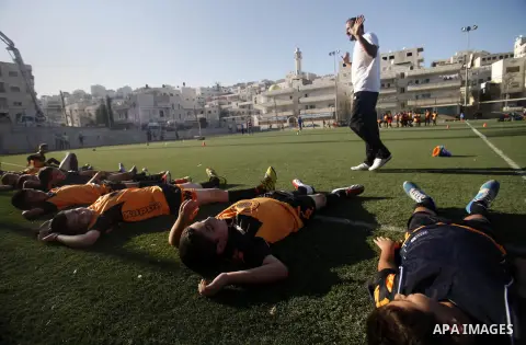 Palestinian boys play soccer during training exercises at a playground in Jerusalem, Aug. 31, 2013. About 200 Palestinian boy from the West Bank participated in the exercises to join the Palestinian Football Academy for...