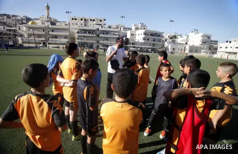 Palestinian boys play soccer during training exercises at a playground in Jerusalem, Aug. 31, 2013. About 200 Palestinian boy from the West Bank participated in the exercises to join the Palestinian Football Academy for...