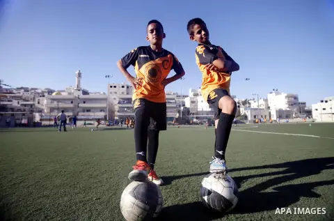 Palestinian boys play soccer during training exercises at a playground in Jerusalem, Aug. 31, 2013. About 200 Palestinian boy from the West Bank participated in the exercises to join the Palestinian Football Academy for...