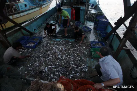 Palestinian fishermen work on their boat at the Gaza seaport in the west of Gaza City, 02 September 2013. The Egyptian navy boats attacked the Palestinian boats off the southern Gaza Strip last Friday, near the border wi...