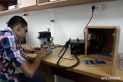 Palestinian engineer Mohammed Ajoor, 24, works on a cradle project at his home in Gaza City on Sep 04, 2013. The aim of the project is to construct an intelligent system which is capable of identifying the cry of baby an...