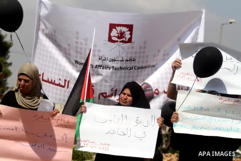 Palestinian women hold placards during a protest calling for adoption a new act to protect Palestinian women from violence, in the West Bank city of Ramallah on Sep. 05, 2013. Photo by Issam Rimawi