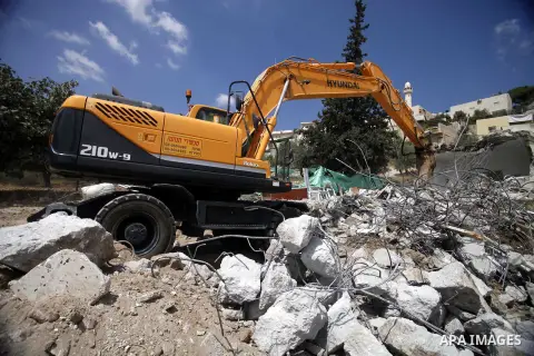 A picture taken on Sep 05, 2013, shows a bulldozer demolishing the home of Shaker Ja'abis in Jabel Mukaber neighborhood southern Jerusalem. Ja'abis decided to demolish his own home to carry out an Israeli court order und...