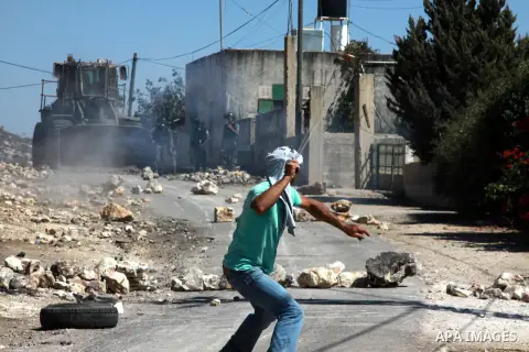 A Palestinian protester hurls stones at Israeli security forces during clashes in the weekly protest against the Jewish settlement of Qadomem, near Nablus, West Bank, 06 September 2013. Thirteen Palestinians were injured...
