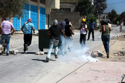 Palestinian protesters run for cover from tear gas fired by Israeli forces during clashes in the weekly protest against the Jewish settlement of Qadomem, near Nablus, West Bank, 06 September 2013. Thirteen Palestinians w...