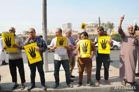 Supporters of Egypt's ousted President Mohammed Morsi chant slogans and hold placards showing an open palm with four raised fingers, which has become a symbol of the Rabaah al-Adawiya mosque, where Morsi supporters had h...