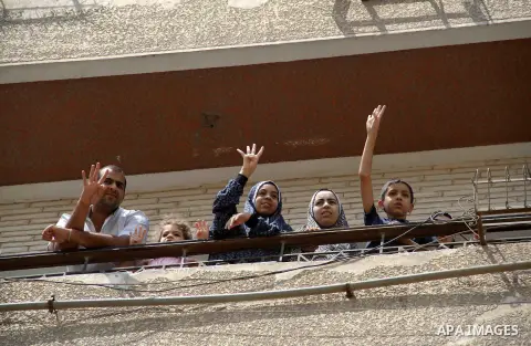 Supporters of Egypt's ousted President Mohammed Morsi chant slogans and hold placards showing an open palm with four raised fingers, which has become a symbol of the Rabaah al-Adawiya mosque, where Morsi supporters had h...