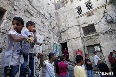 Palestinians gather in front of cracked walls in the al-Qirami quarter in the old town of Jerusalem, Sept. 11, 2013. Landslides occurred Wednesday due to the network of tunnels that Jerusalem's municipality is digging th...