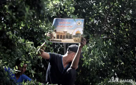 A Palestinian man shouts anti-Israeli slogans as he holds up a poster of Jerusalem's Al-Aqsa compound during a protest in Gaza City on September 13, 2013. Israeli police spokeswoman Luba Samri said that restrictions woul...