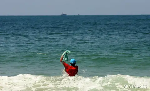 A Palestinian fisherman throw his fishing net in the Mediterranean Sea off the coast of Rafah in the southern Gaza Strip, near Egypt's territorial water September 15, 2013. Israeli naval vessels on Sunday fired on Palest...