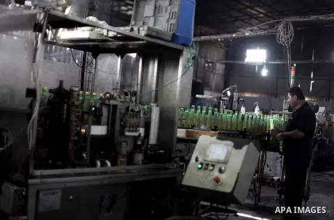 A Palestinian man works at al-Madina factory, a local soft drinks production line, in Gaza City on Sept. 15, 2013. The production line threatened to stop working since the crackdown campaign of Egyptian security forces o...