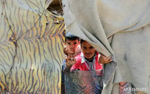 Palestinian Bedouin children play outside their tents near the sewage water basins in the northern Gaza Strip, Sept. 19, 2013. The area is threatened with an environmental and humanitarian disaster due to the accumulatio...