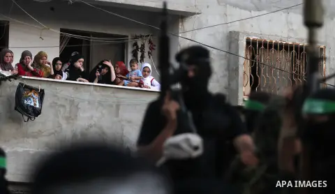 Palestinian militant members of the military Hamas wing Izz Ad-Dine Al-Qassam Brigades are seen during a march along the streets of Al Shatee refugee camp in Gaza City, 21 September 2013. Photo by Ashraf Amra