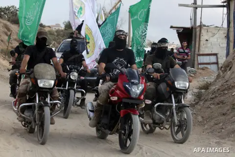Palestinian militant members of the military Hamas wing Izz Ad-Dine Al-Qassam Brigades are seen during a march along the streets of Al Shatee refugee camp in Gaza City, 21 September 2013. Photo by Ashraf Amra